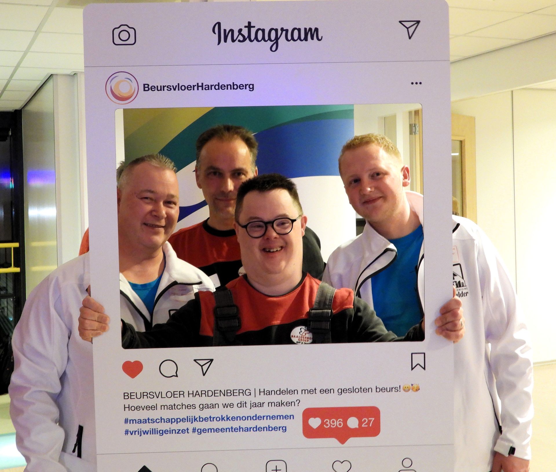 Vier mensen in een groot Instagram-kader, lachend. Interieur.