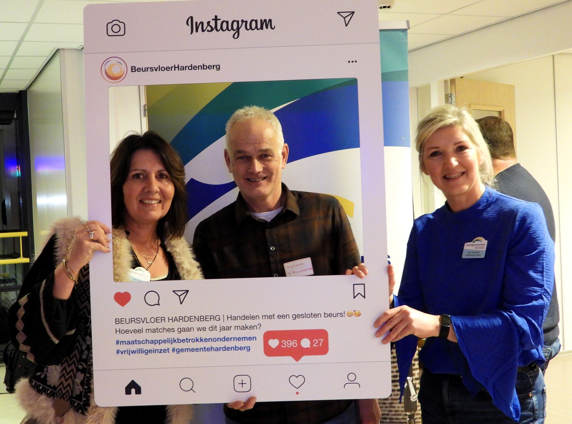 Drie mensen poseren lachend met een Instagram-fotolijst. Eén houdt de lijst aan elke kant vast, de derde zit erin.