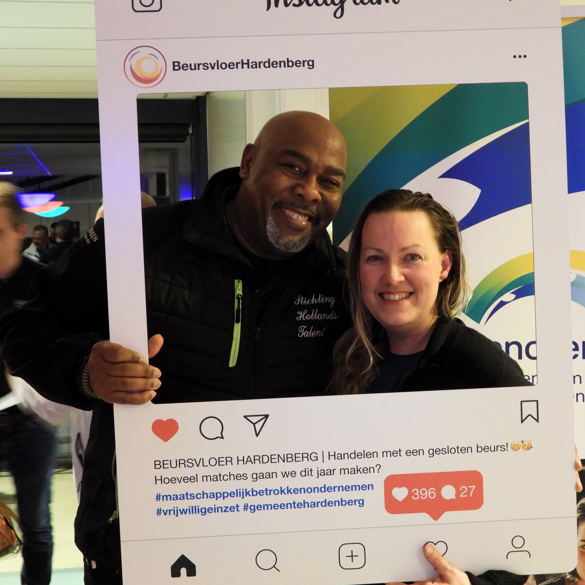 Twee lachende mensen poseren achter een Instagram-frame met Nederlandse tekst.