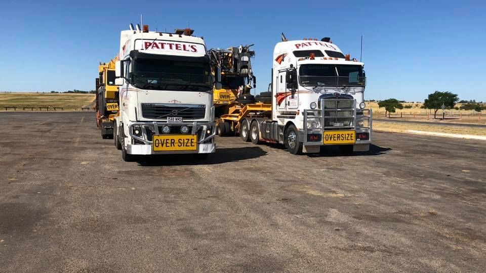 Two Trucks Are Parked Next To Each Other In A Parking Lot — Pattel's Heavy Haulage Townsville Pty Ltd In Garbutt, QLD
