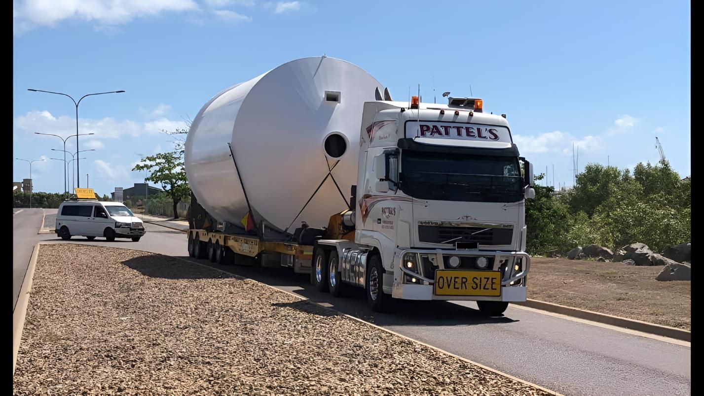 A Large White Truck Is Driving Down A Gravel Road — Pattel's Heavy Haulage Townsville Pty Ltd In Garbutt, QLD