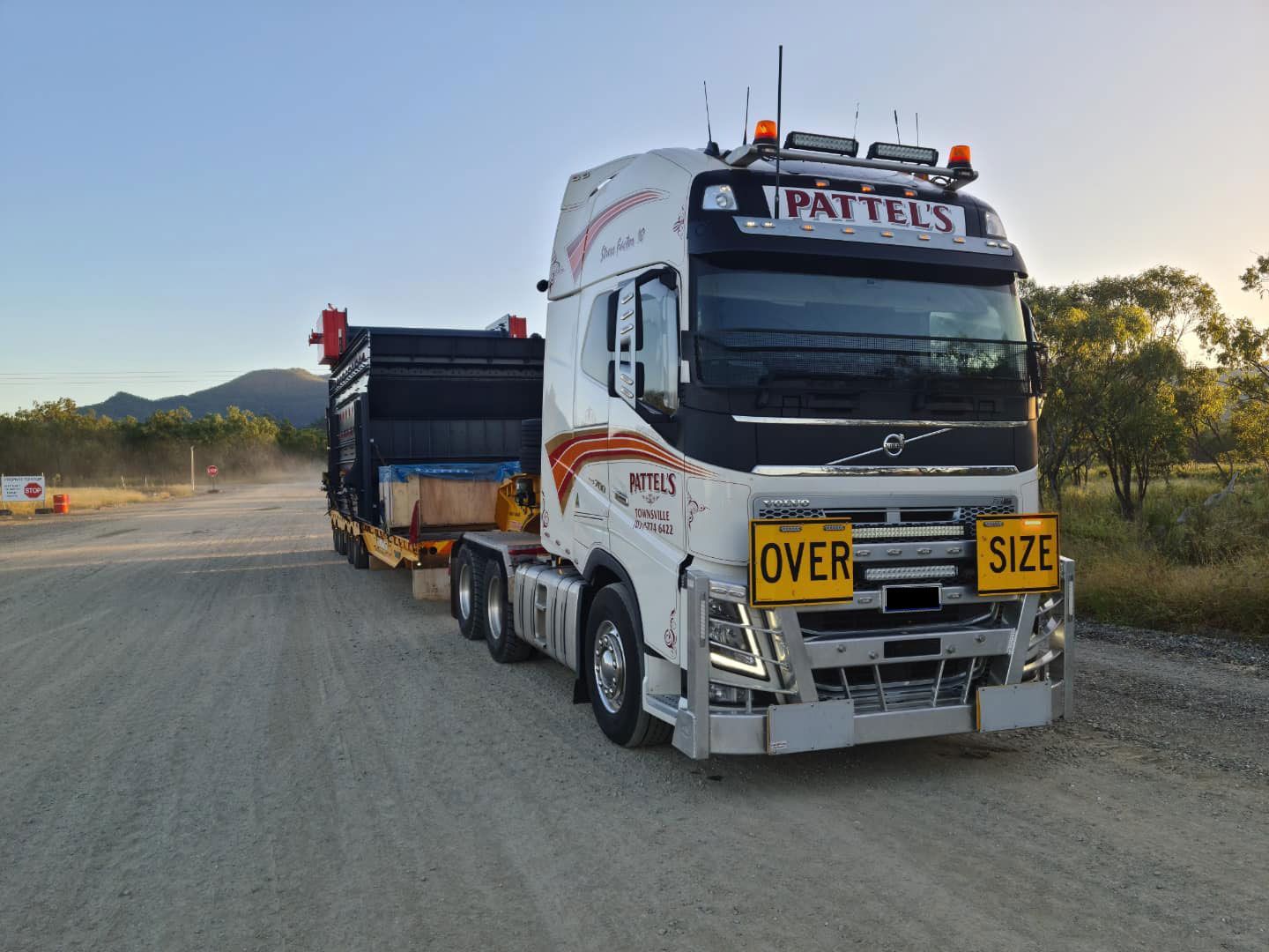 A Large Semi Truck Is Driving Down A Dirt Road — Pattel's Heavy Haulage Townsville Pty Ltd In Garbutt, QLD