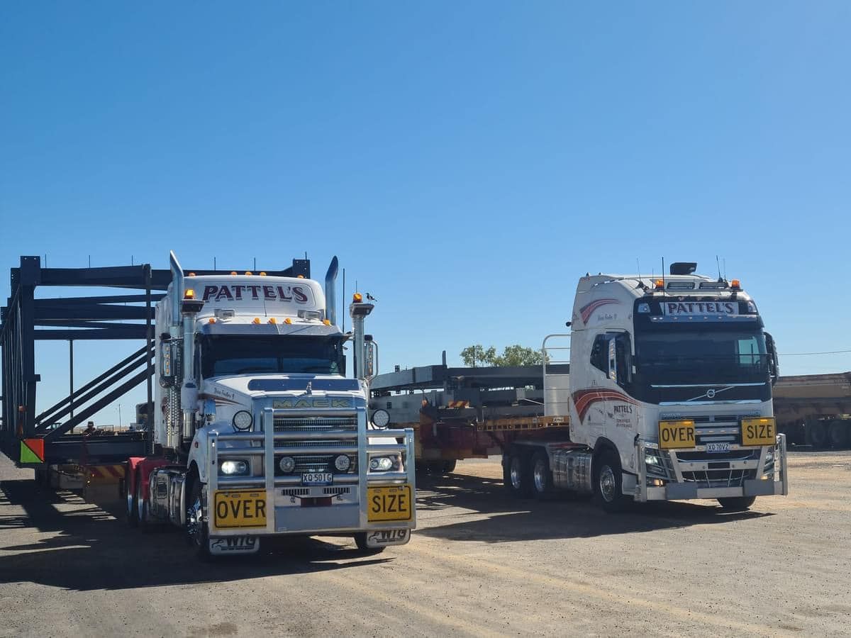 Two Trucks Are Parked Next To Each Other On A Dirt Road — Pattel's Heavy Haulage Townsville Pty Ltd In Garbutt, QLD