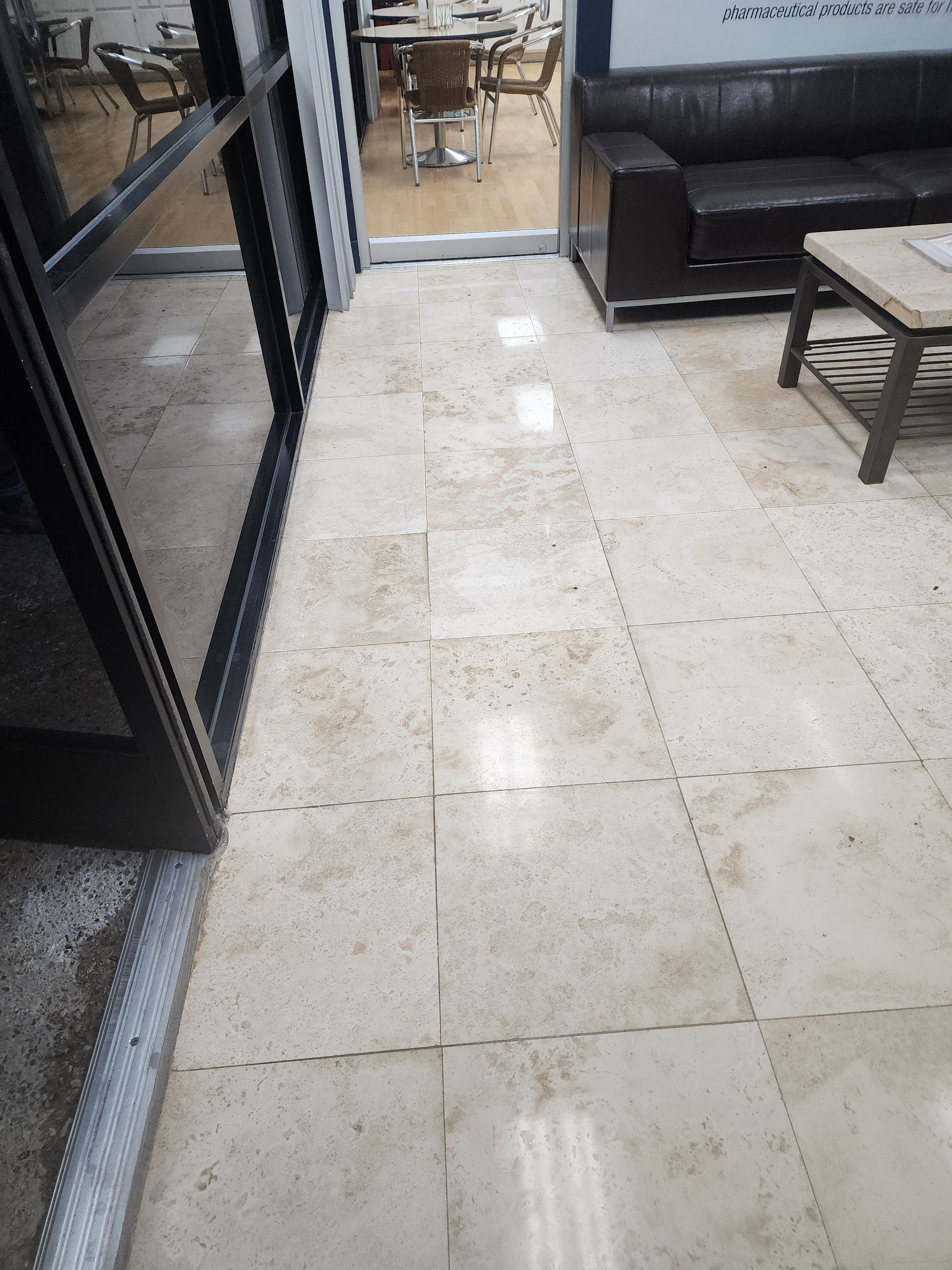 Tiled floor in an indoor space with a glass door, sofa, and small table.
