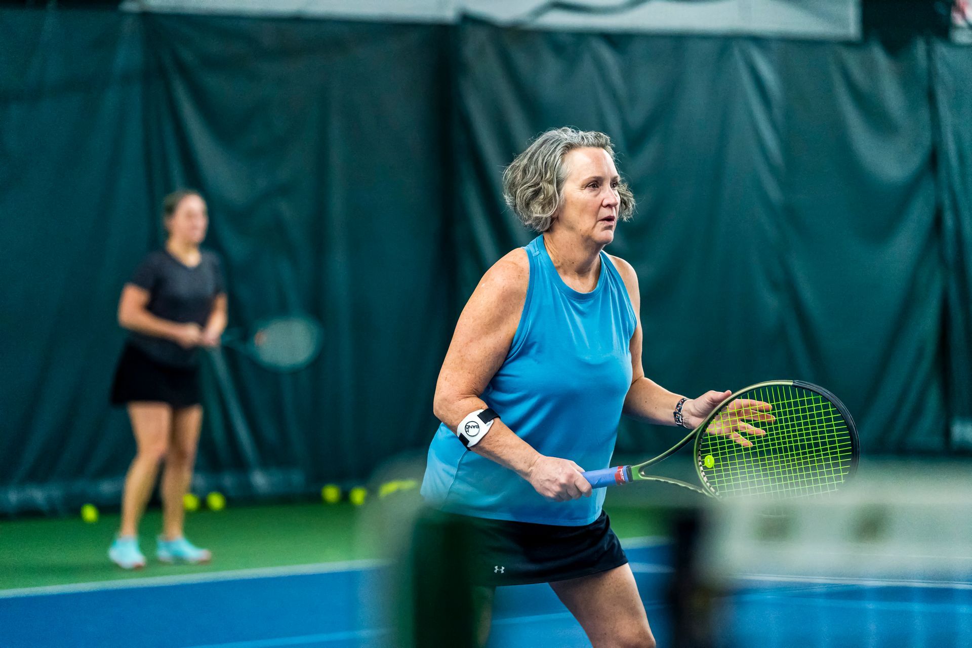 A woman is holding a tennis racquet on a tennis court.