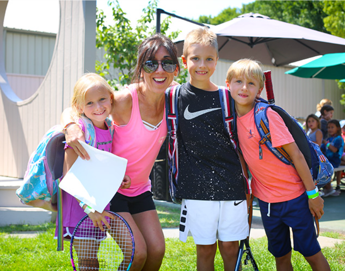 A woman is posing for a picture with three children.