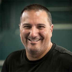 A man with a beard wearing a black shirt smiles for the camera