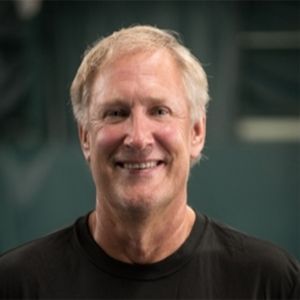 A man wearing a black shirt is smiling for the camera