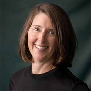 A woman in a black shirt is smiling for the camera.