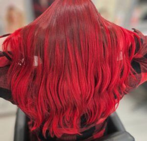 Vibrant, long, wavy red hair styled in a salon setting.