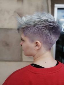 Short, textured hair styled with a fade, colored with a silver-to-lavender gradient, shown in profile.