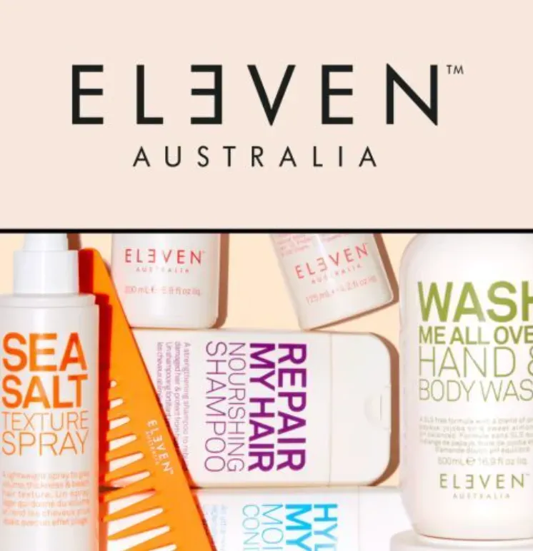 An Eleven Australia promotional image featuring assorted hair and body care bottles and an orange comb against a cream background.