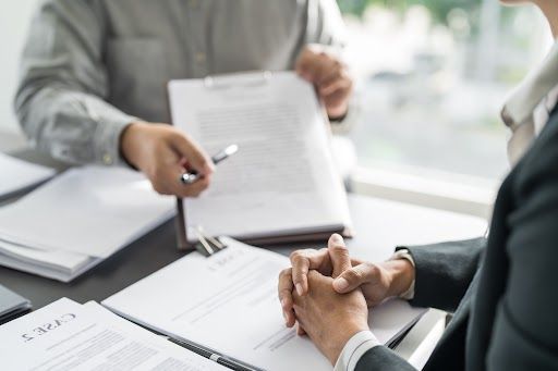 A man and a woman are sitting at a table looking at papers.