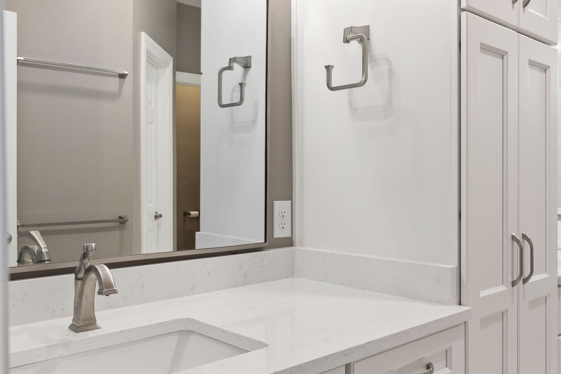 A bathroom with a sink , mirror and cabinets.
