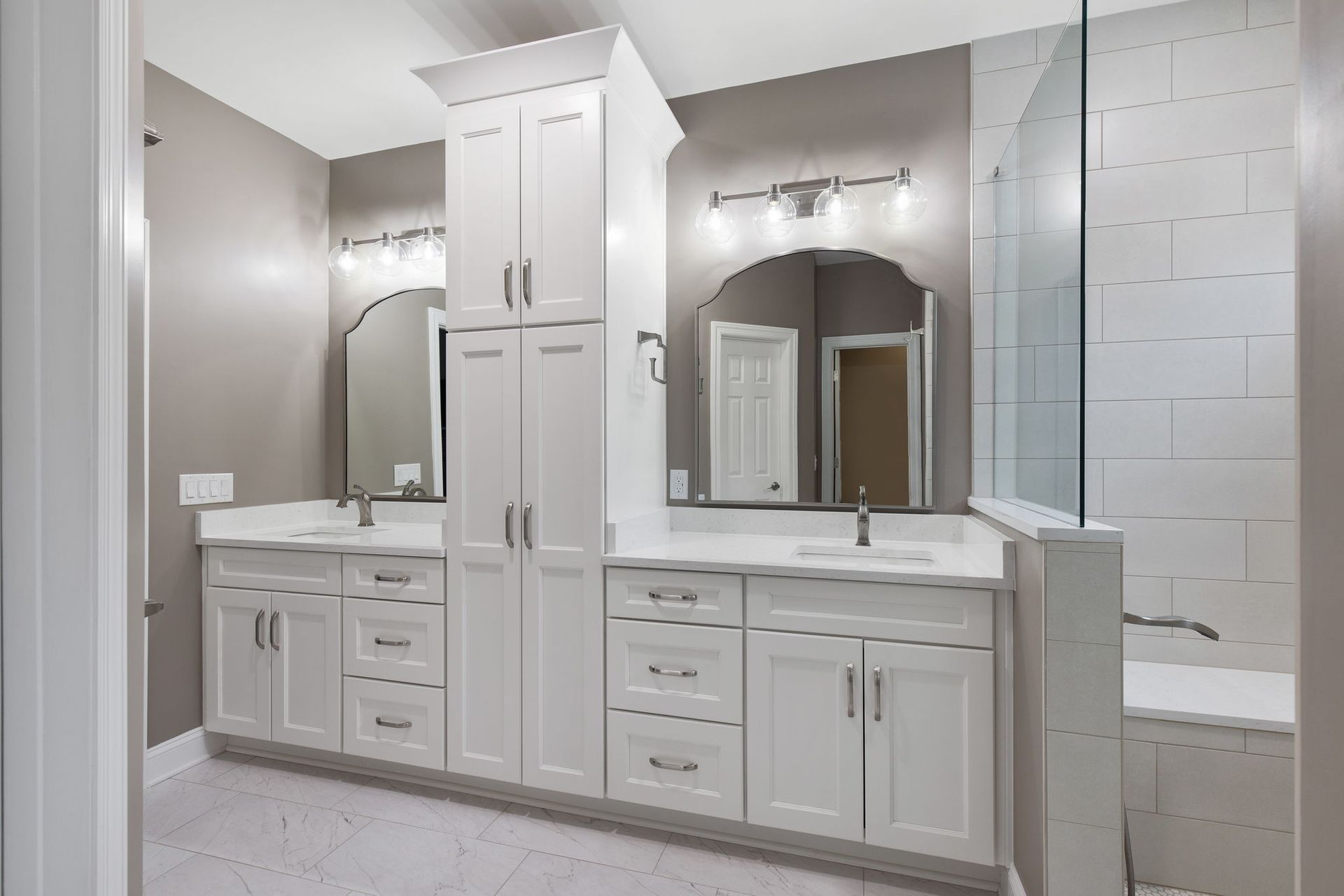 A bathroom with two sinks , a mirror and a tub.