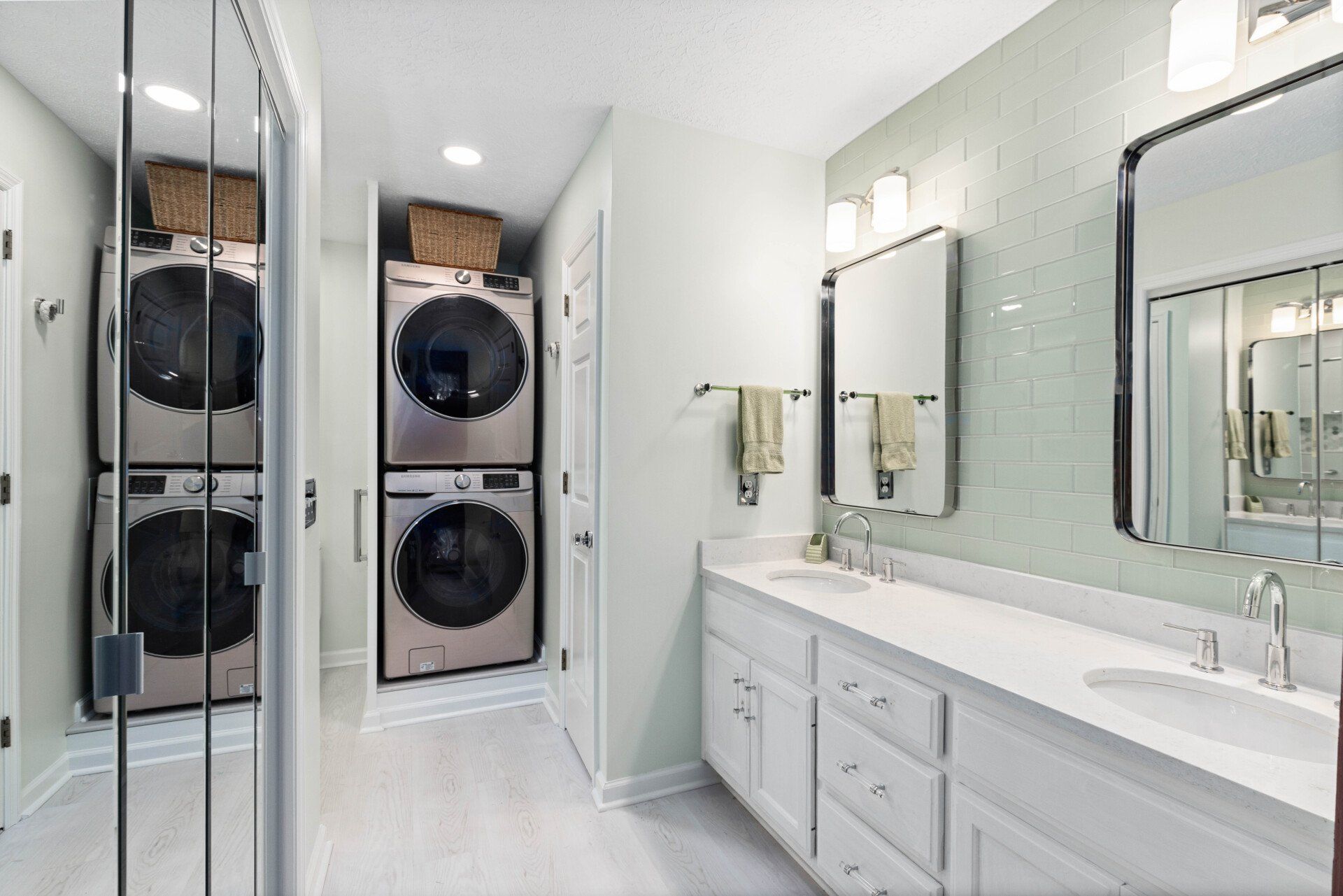 A bathroom with a washer and dryer stacked on top of each other.