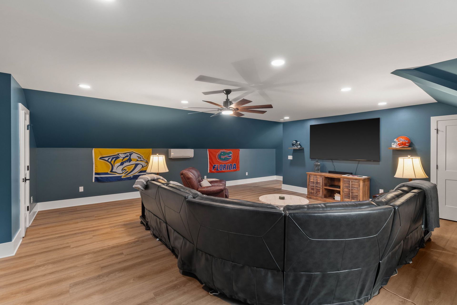 A living room with a large sectional couch and a flat screen tv.