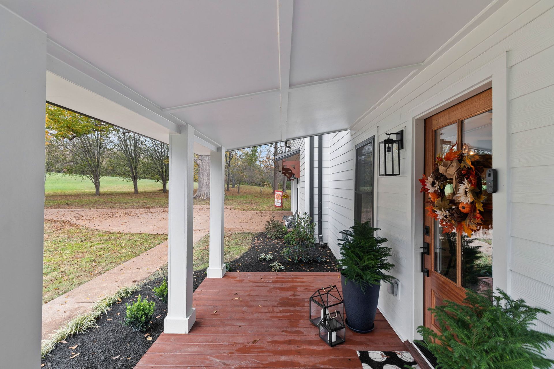 A white house with a porch and a wooden door.