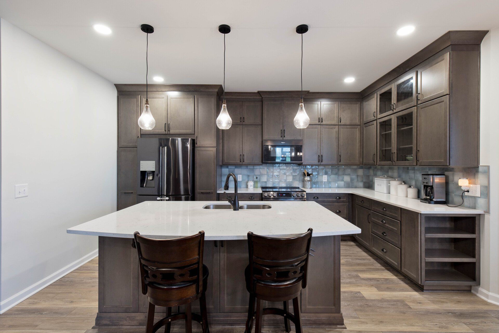 A kitchen with a large island and two chairs