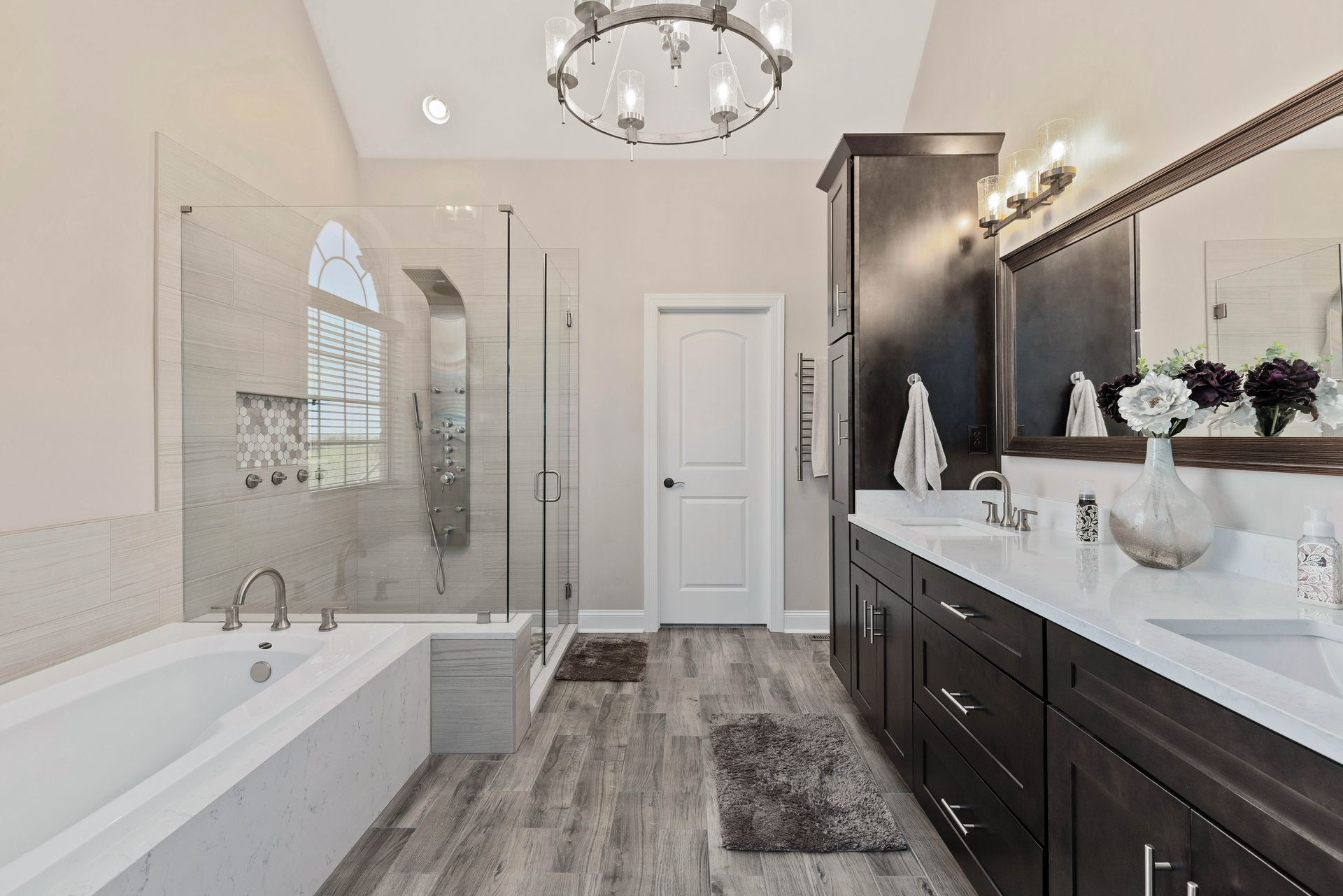 A bathroom with two sinks , a tub and a shower.