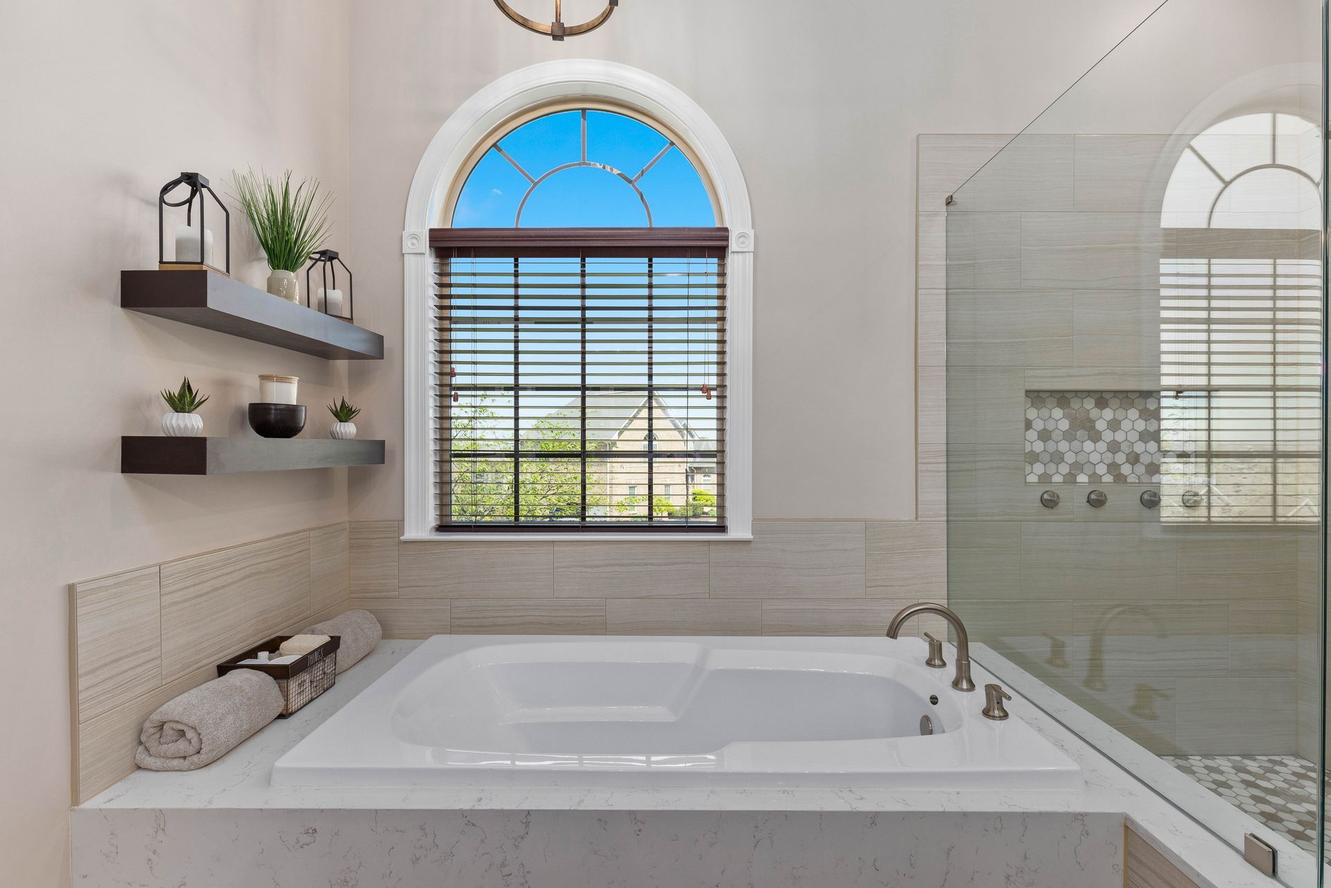 A bathroom with a tub , shower and window.