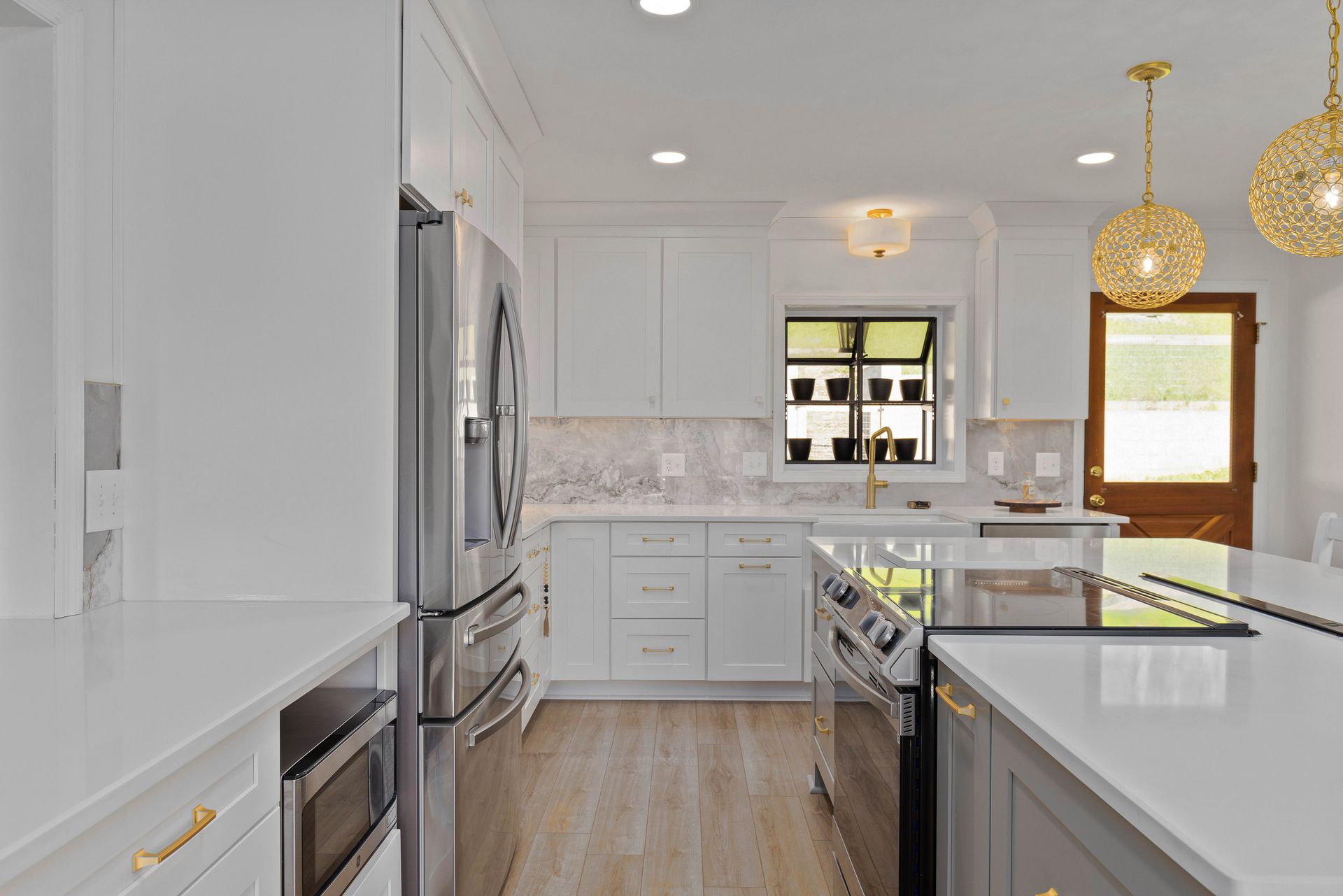 A kitchen with white cabinets and stainless steel appliances.