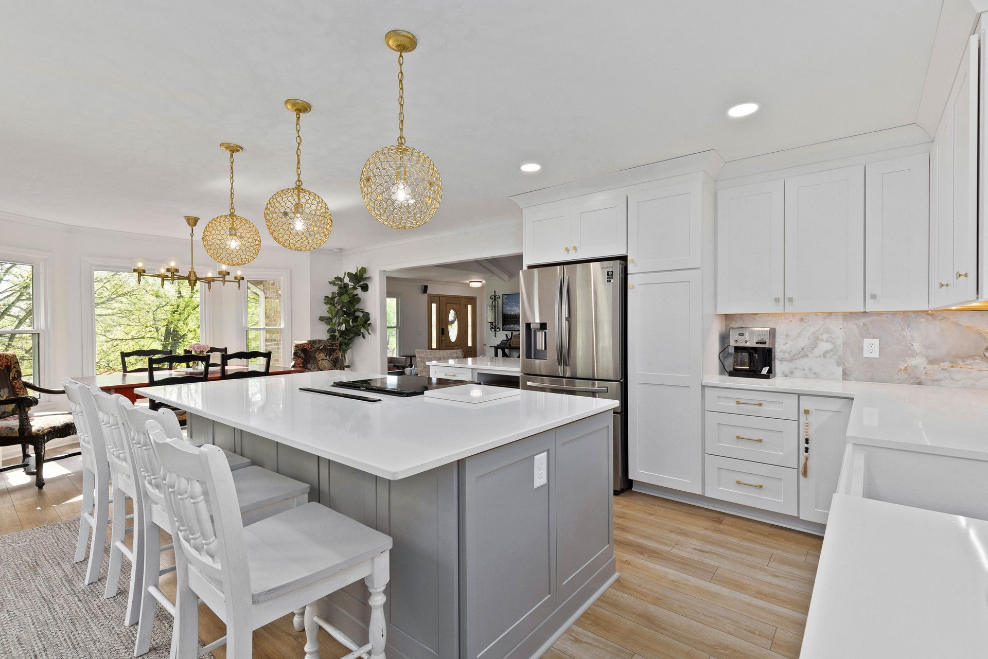 A kitchen with white cabinets and a large island in the middle.