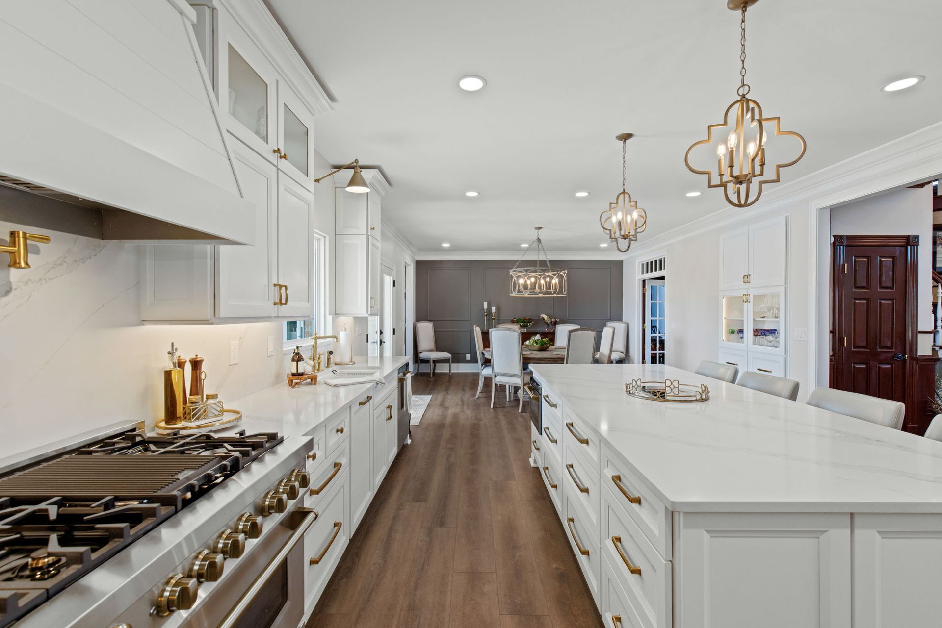 A kitchen with white cabinets and stainless steel appliances and a large island.