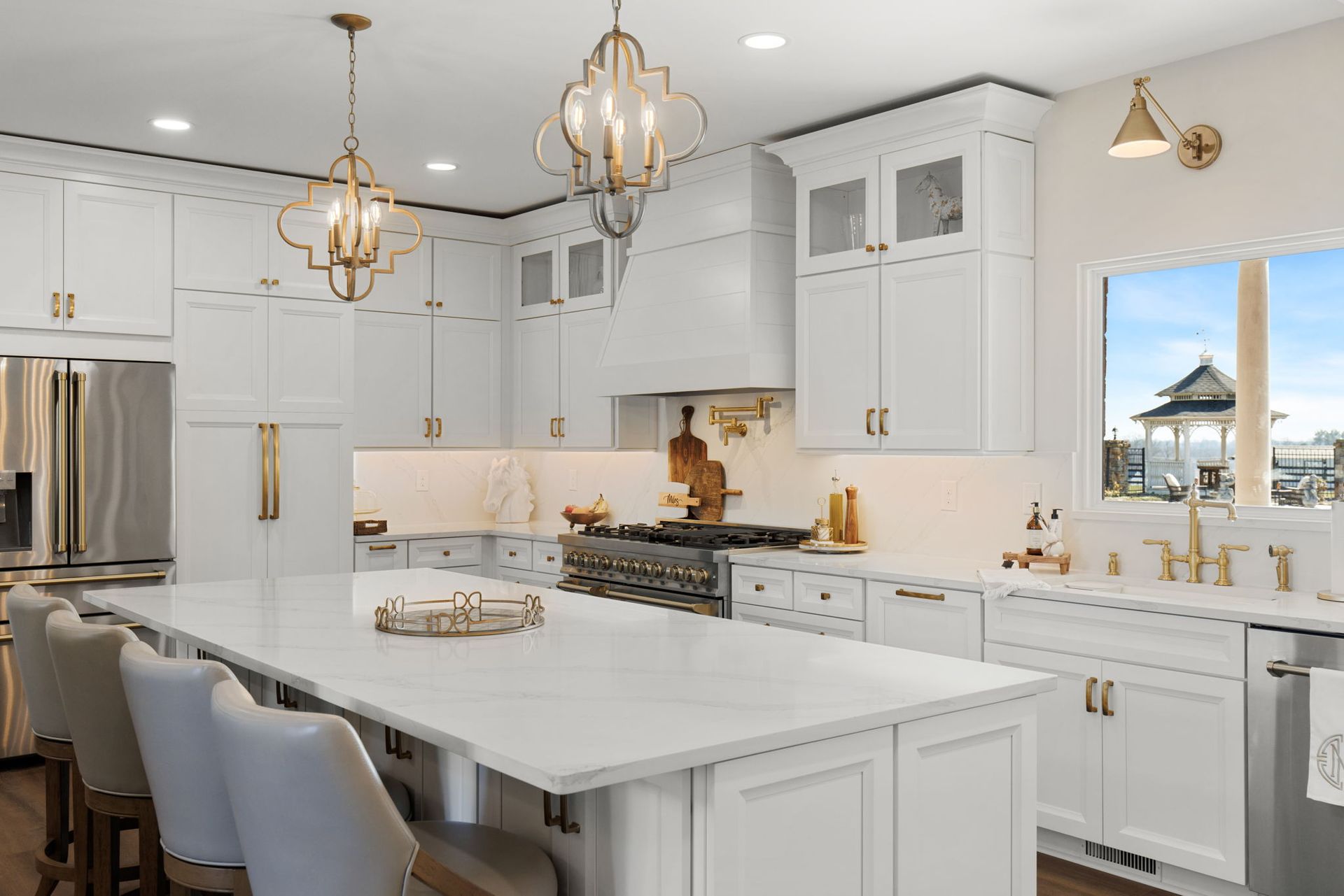 A kitchen with white cabinets , stainless steel appliances , and a large island.