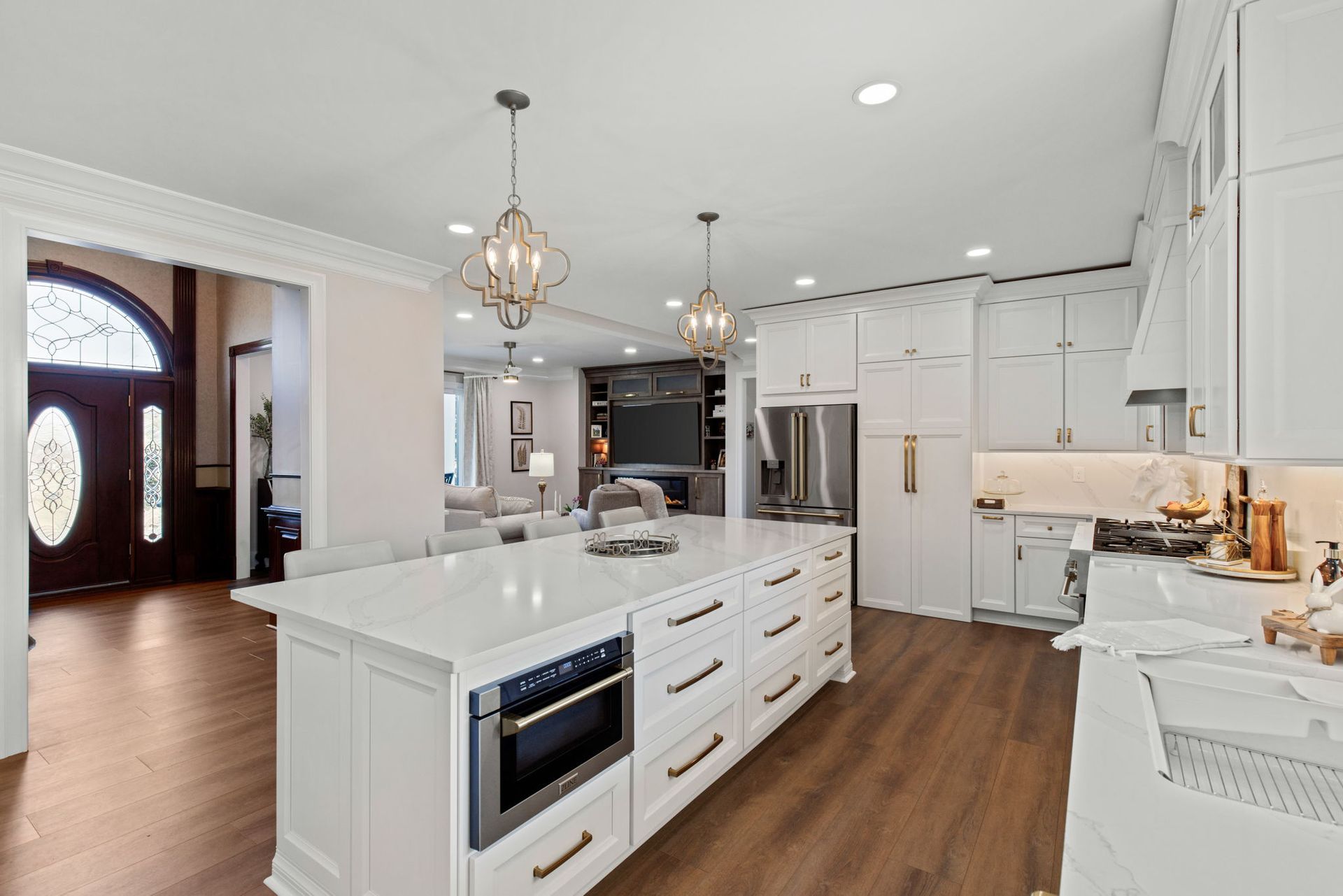 A kitchen with white cabinets and a large island in the middle.