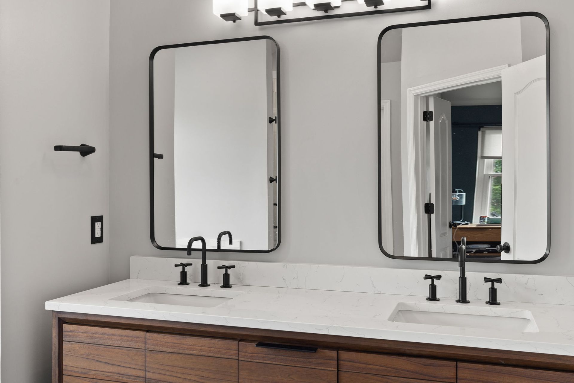 A bathroom with two sinks and two mirrors.