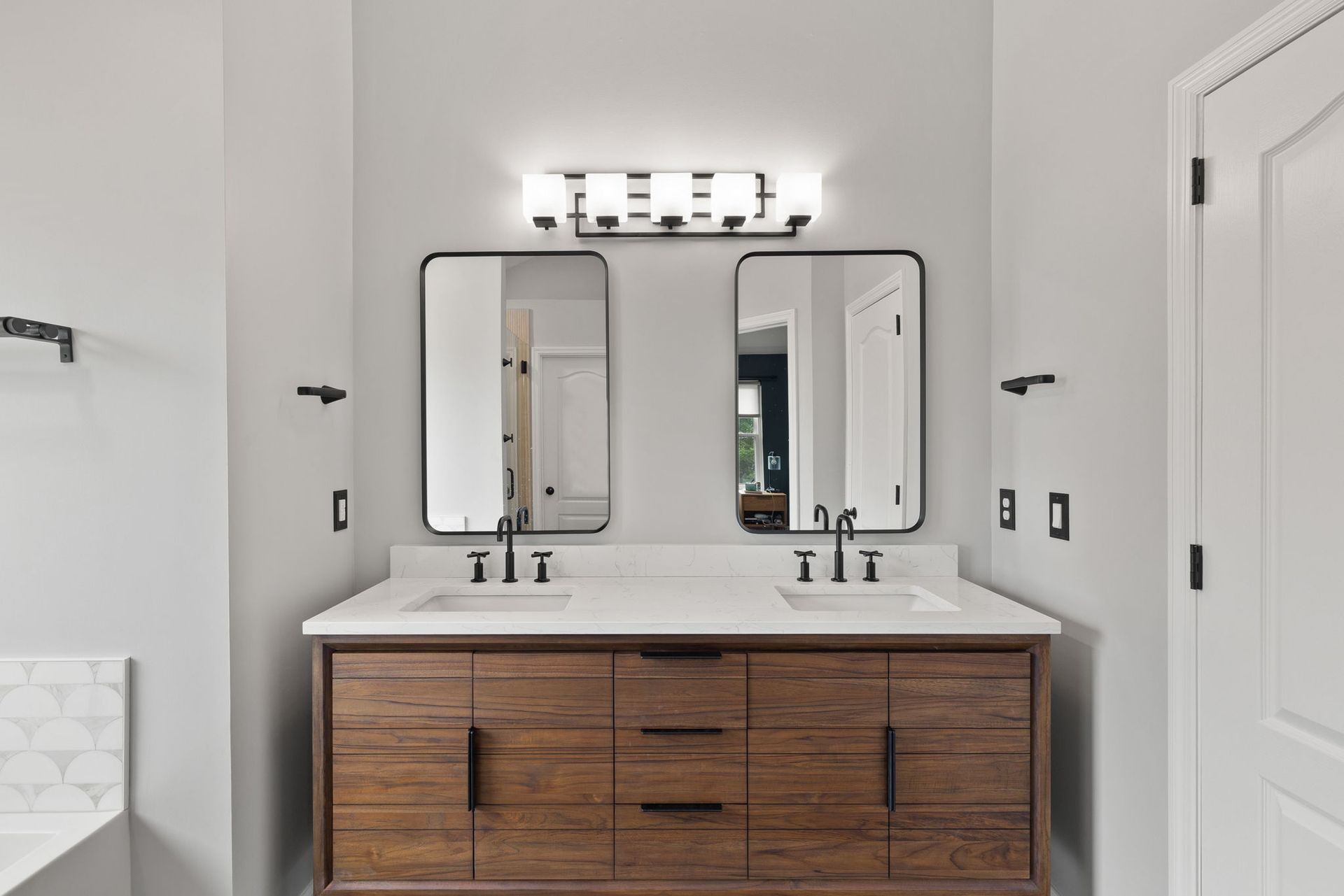A bathroom with two sinks and two mirrors.