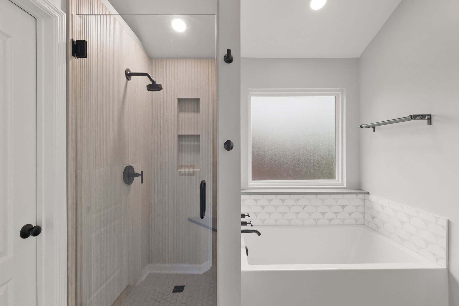 A bathroom with a walk in shower and a bathtub.
