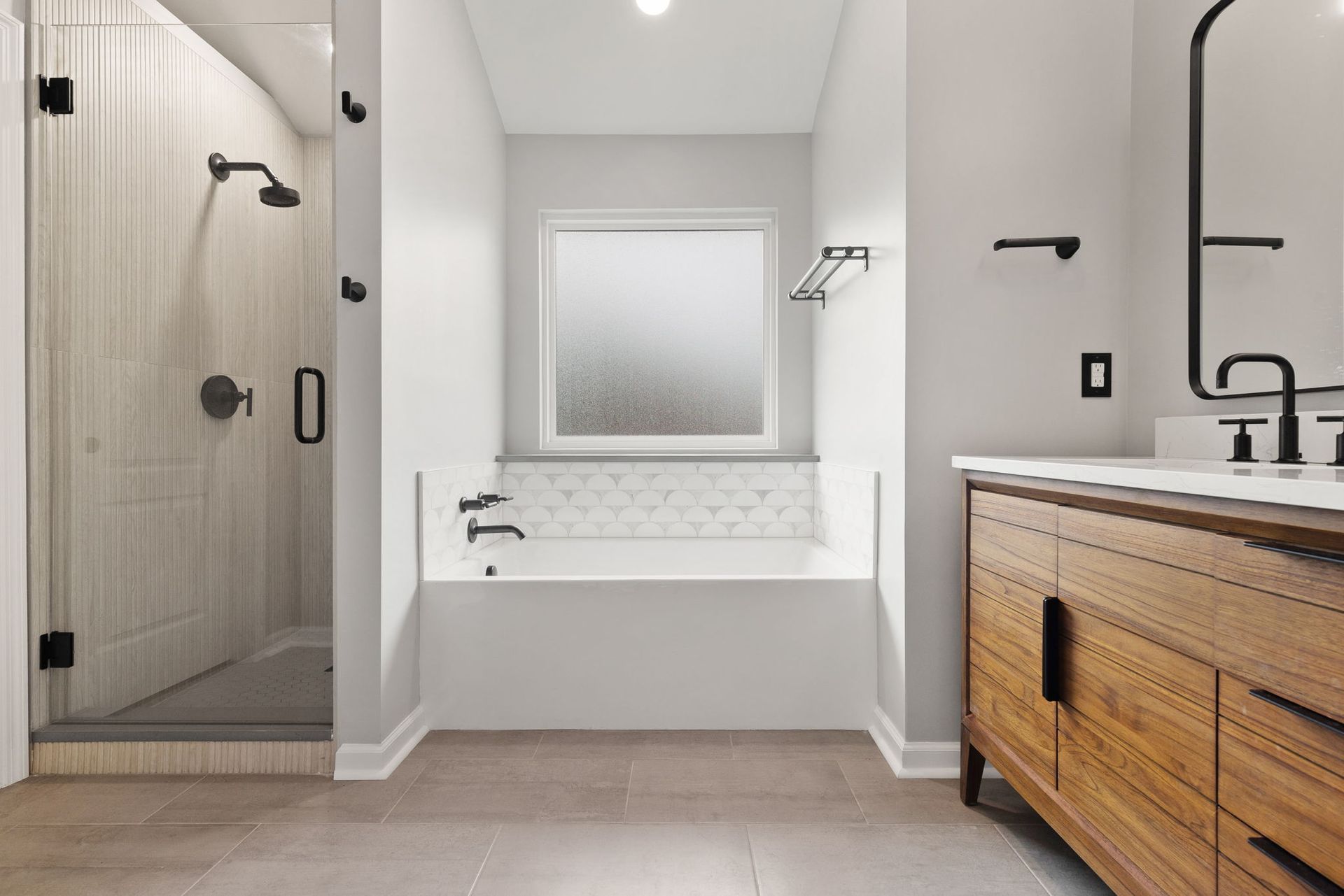 A bathroom with a tub , sink , and shower.