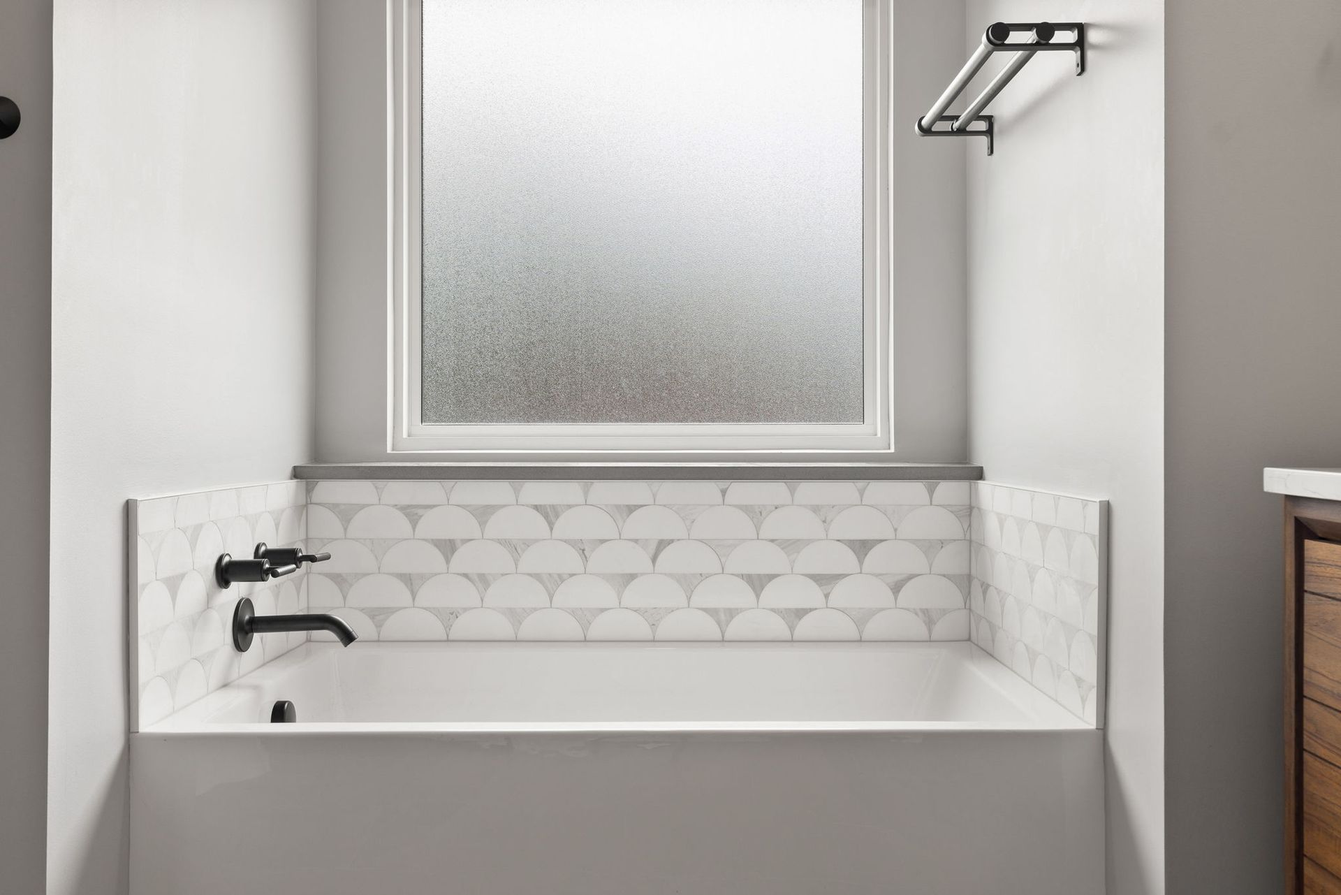 A bathroom with a bathtub and a window.