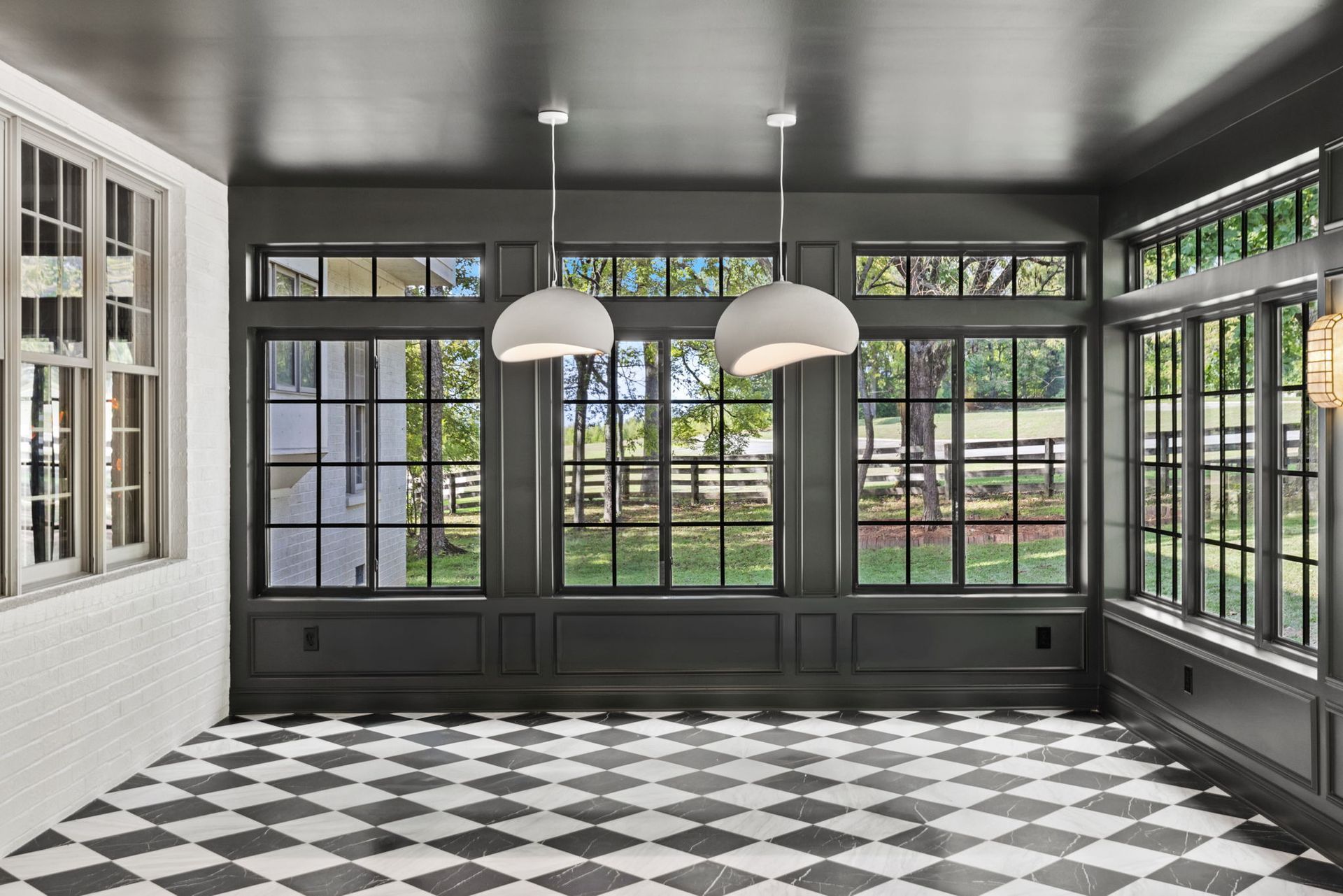 An empty room with a checkered floor and lots of windows.