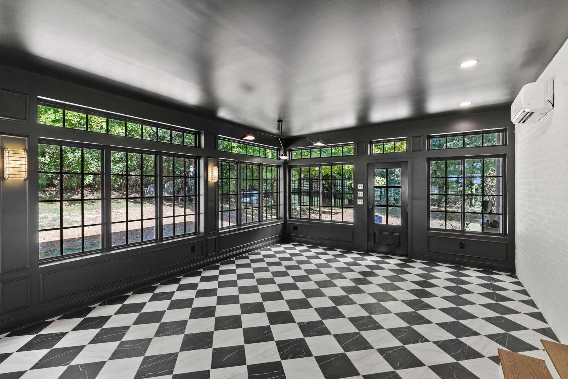 An empty room with a checkered floor and lots of windows.