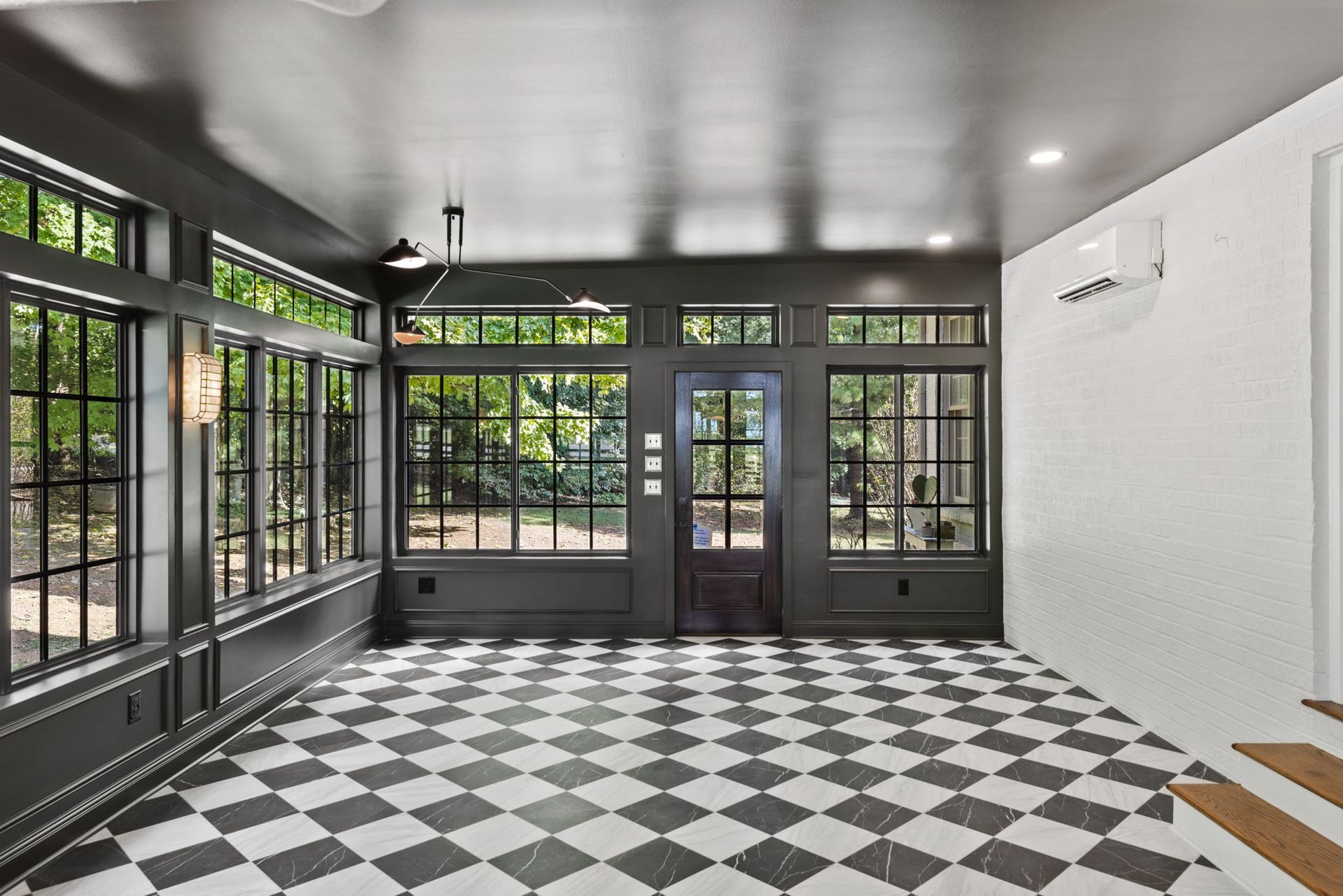 An empty room with a checkered floor and lots of windows.