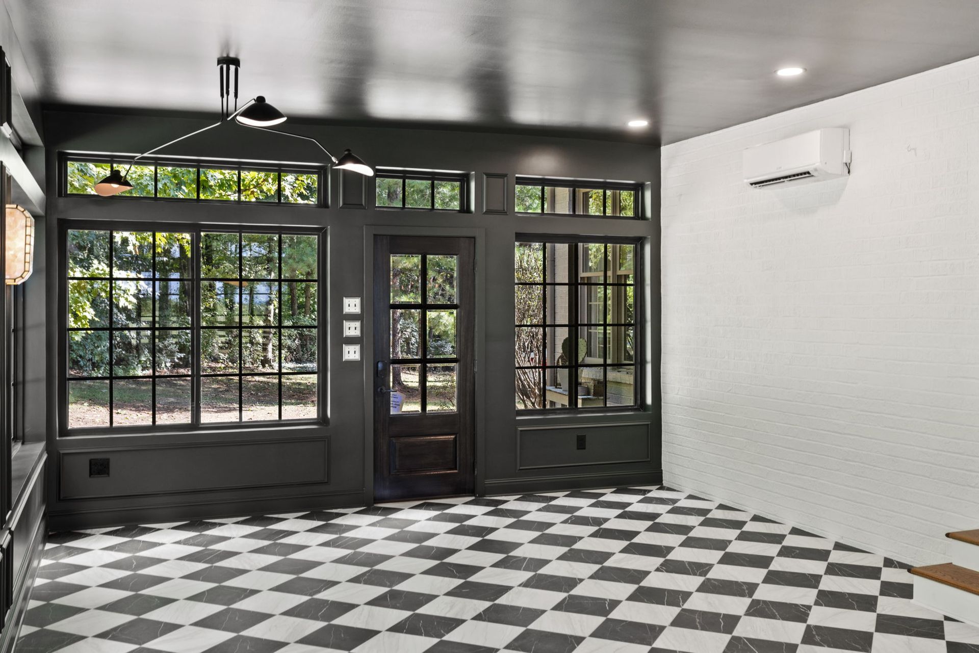 An empty room with a checkered floor and lots of windows.