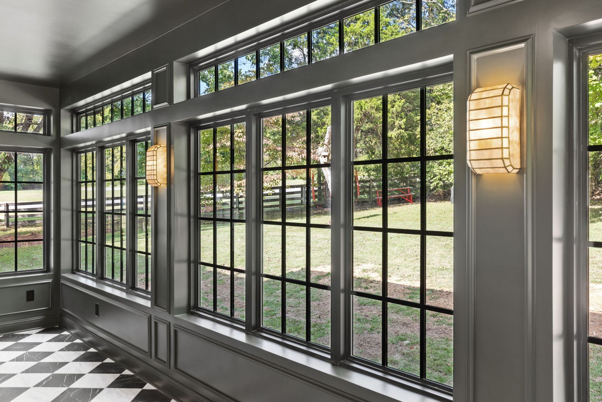 A room with a lot of windows and a checkered floor.