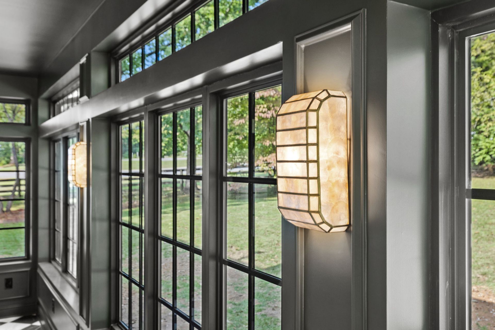 A room with a lot of windows and a light on the wall.