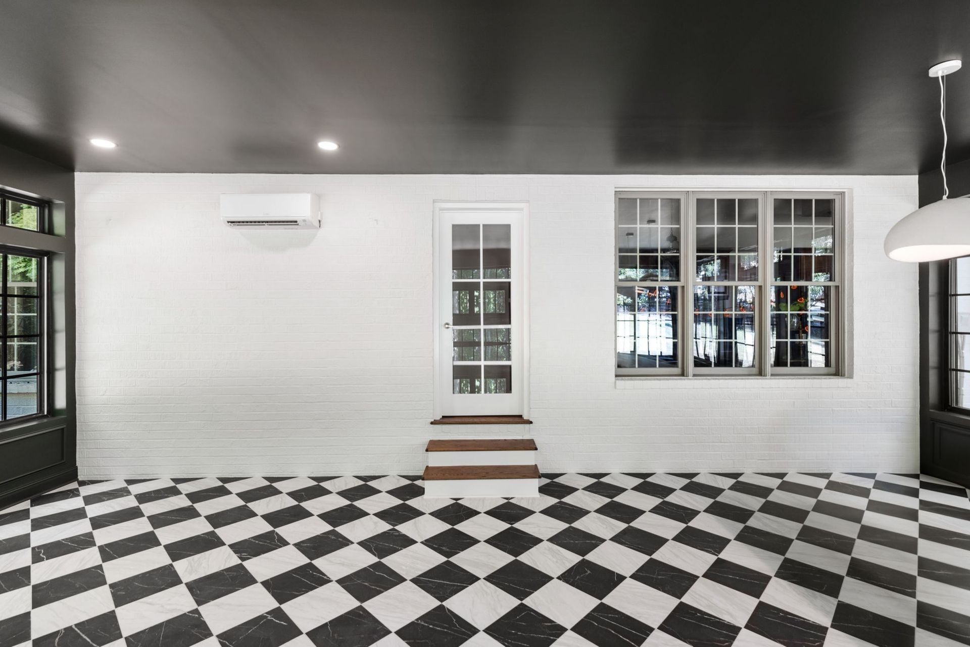 An empty room with a checkered floor and a black ceiling.