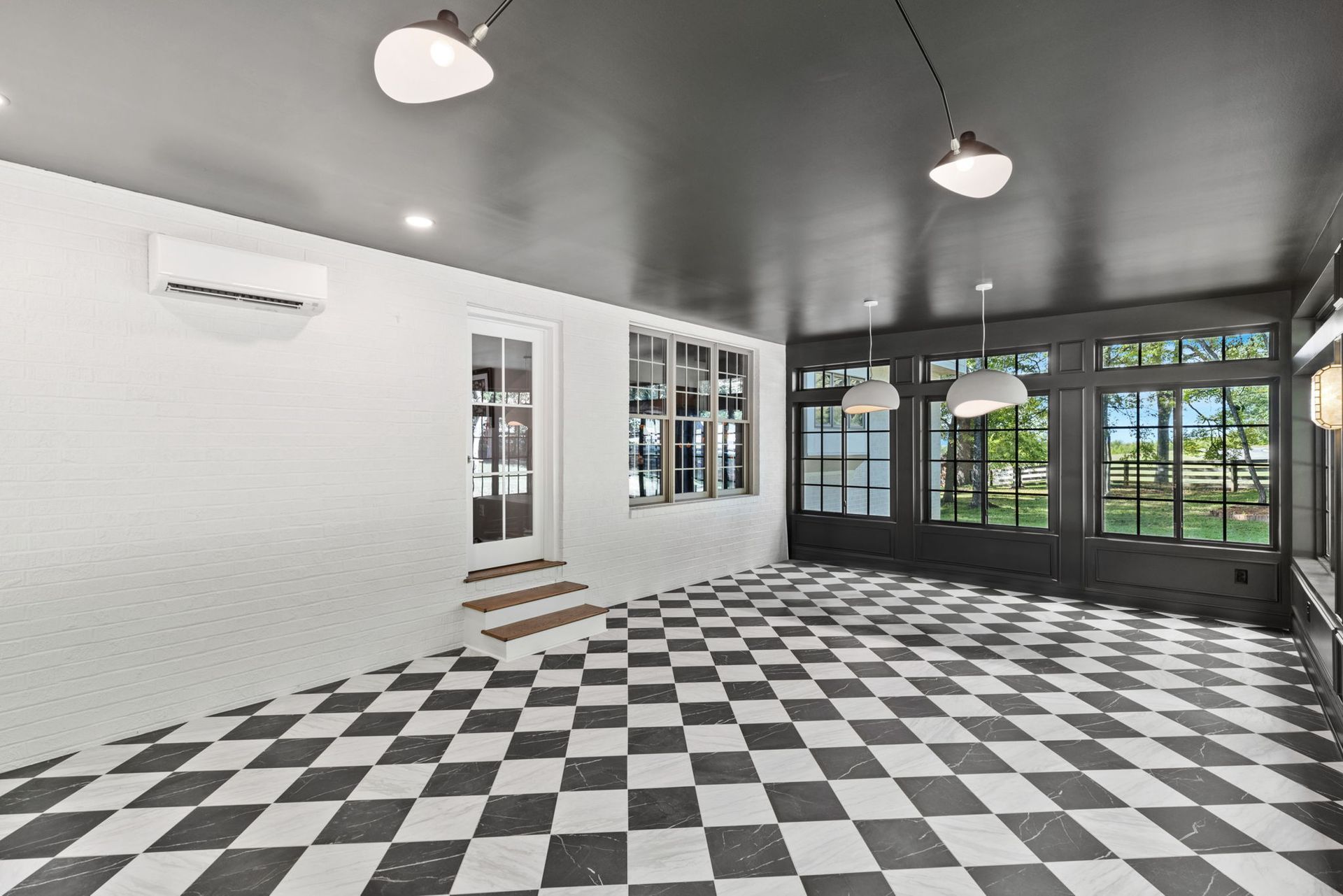 An empty room with a checkered floor and lots of windows.