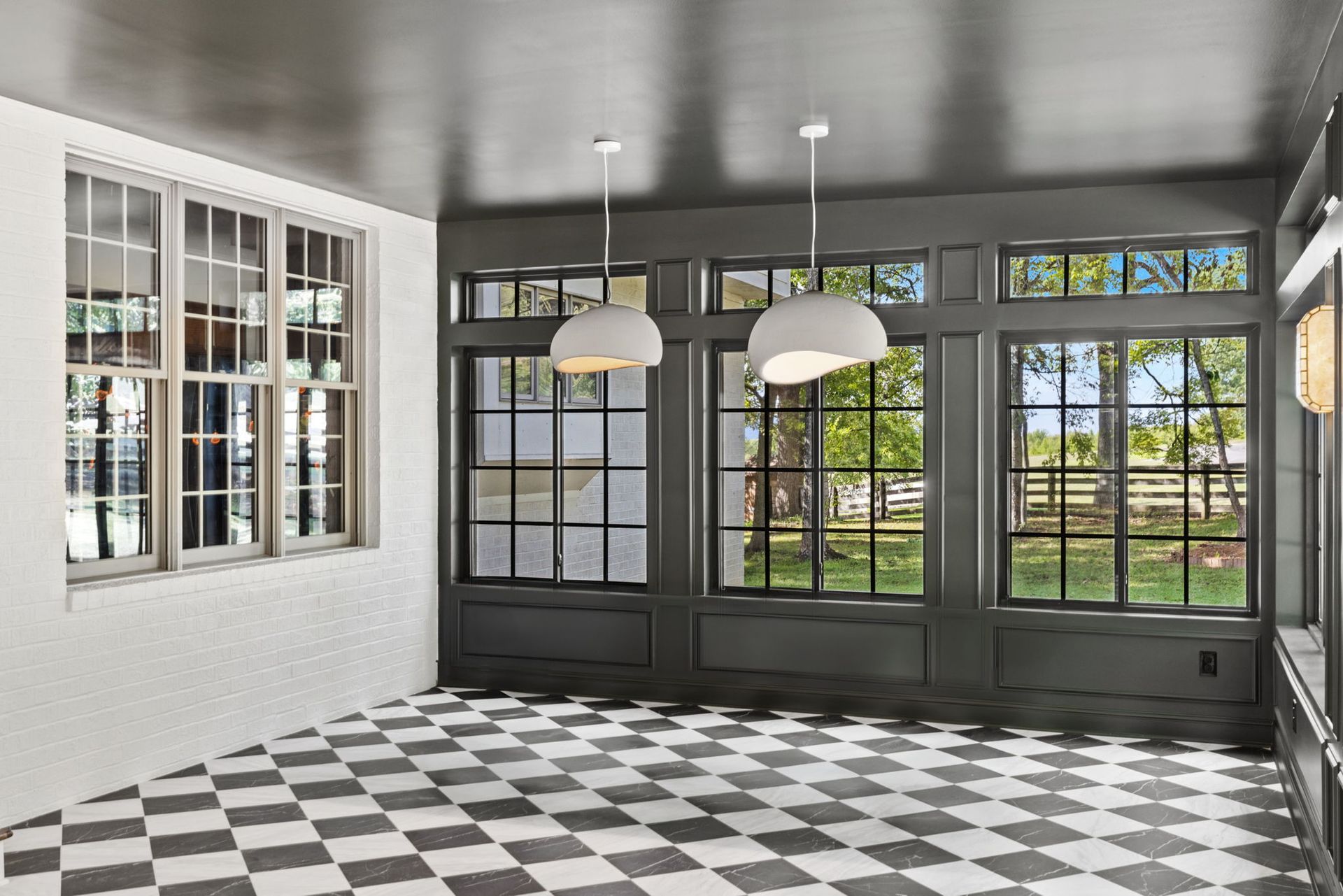 An empty room with a checkered floor and lots of windows.