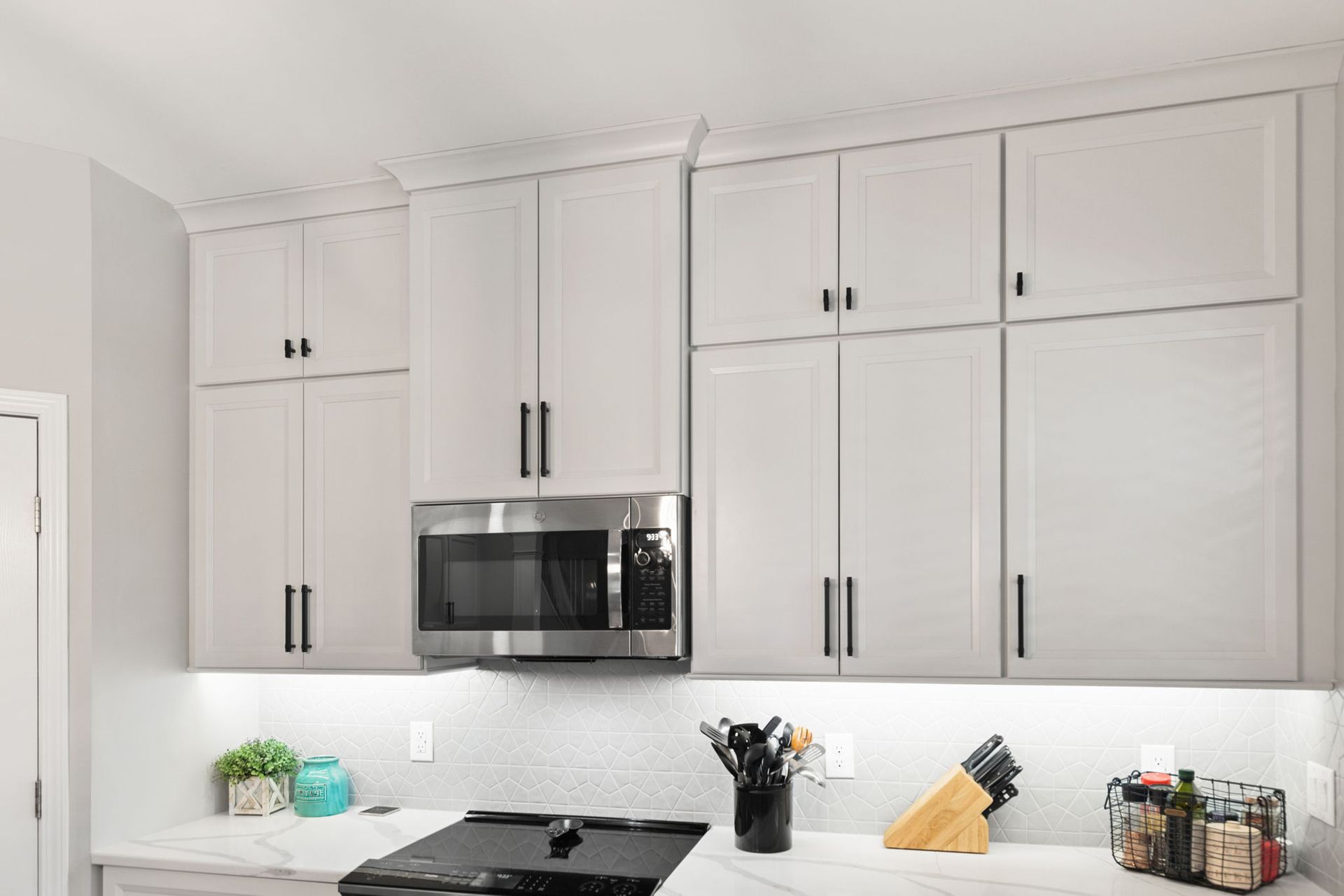 A kitchen with white cabinets and stainless steel appliances.