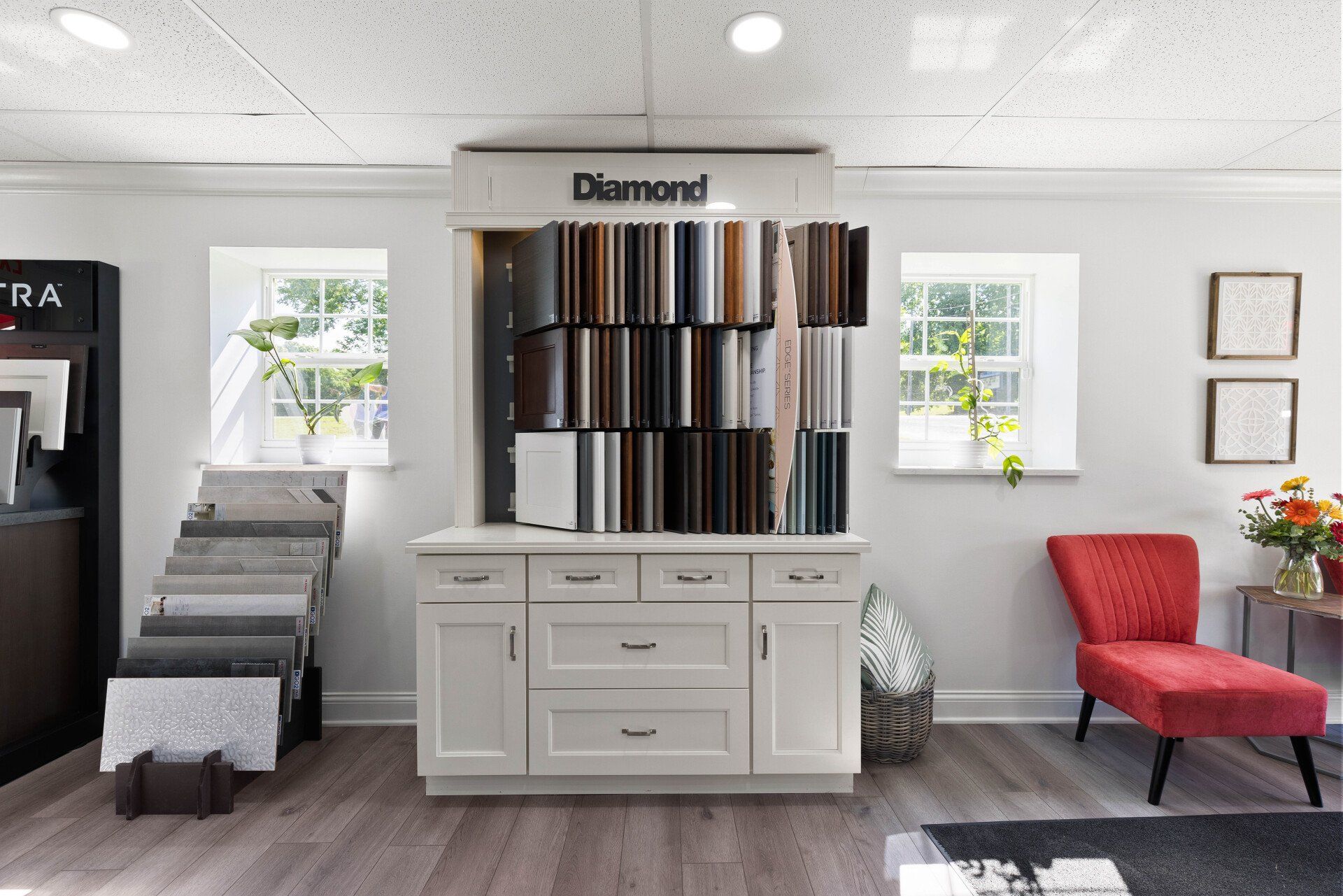 A room with a display of different types of cabinets and a red chair.