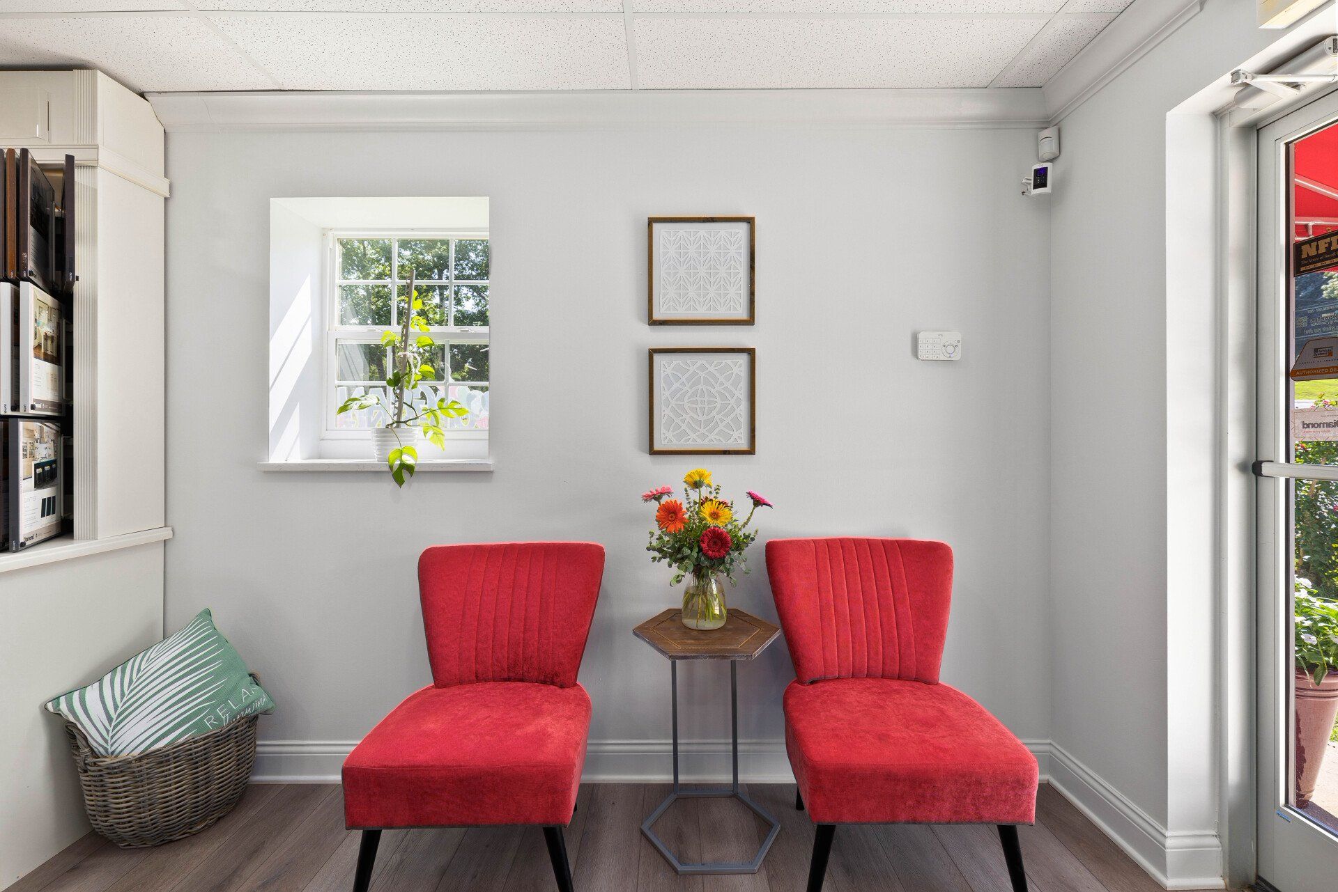 A waiting room with two red chairs and a table.