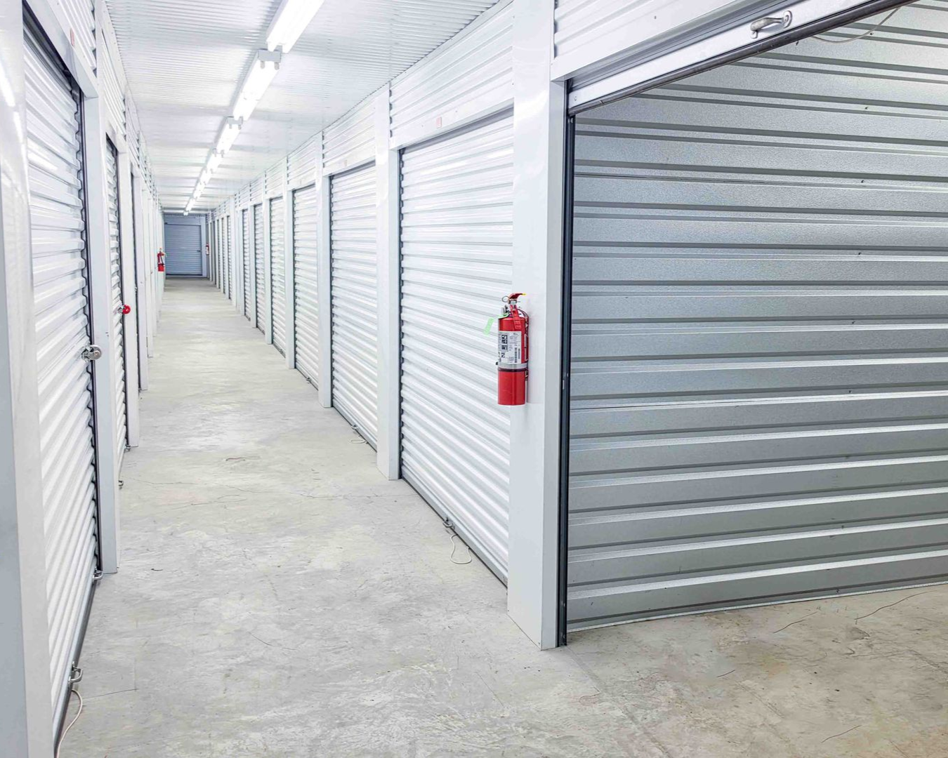 Interior hallway of climate-controlled storage units with a fire extinguisher at Premier Storage & Shipping in Addis, LA