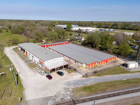 Aerial view of Premier Storage & Shipping in Addis, LA, showing the office building, orange-door drive-up storage units, and gated parking lot