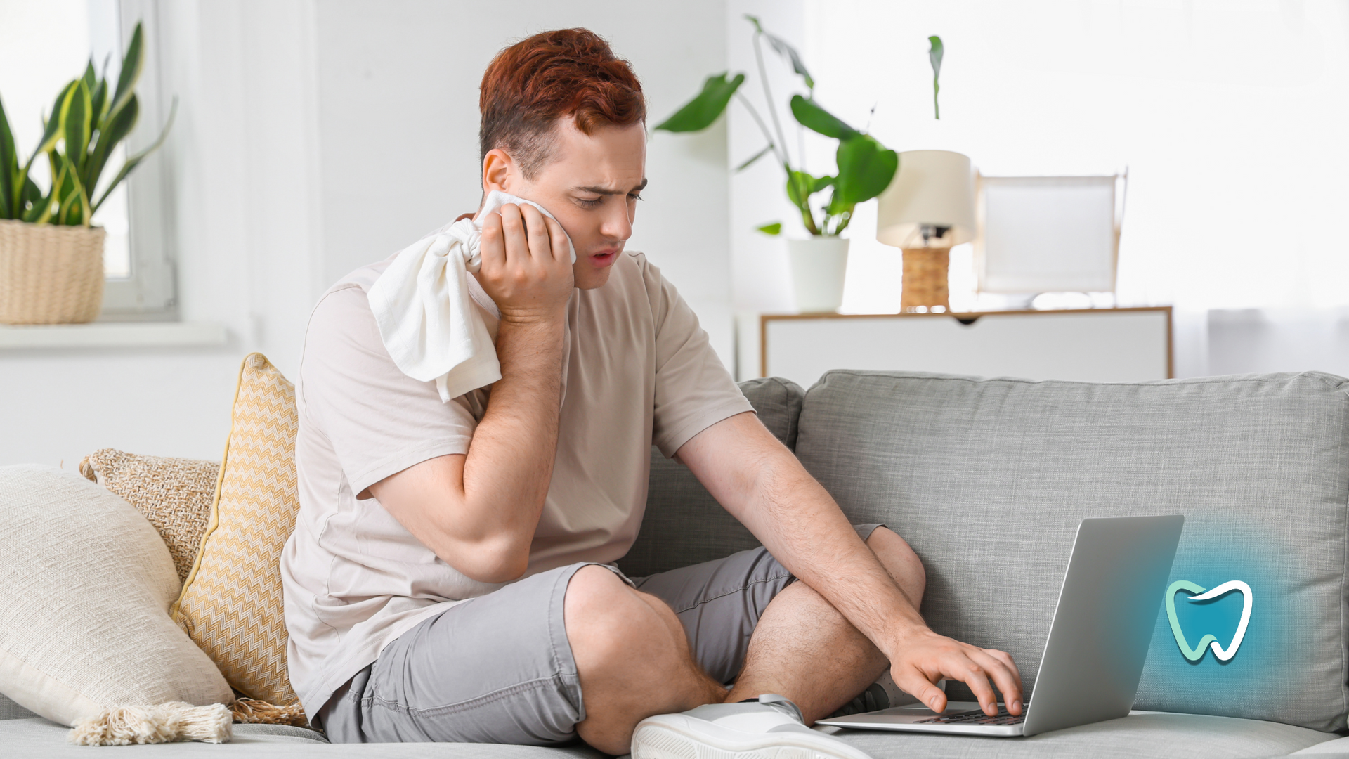 A man is sitting on a couch with a laptop and talking on a cell phone.